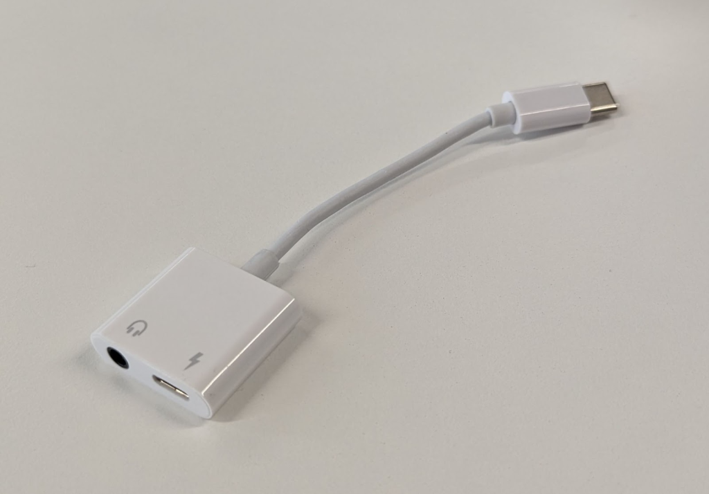 A white USB C to mini jack adapter. 